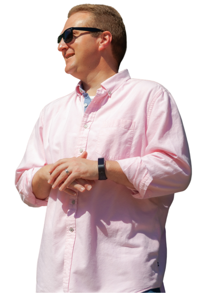 Picture of Bobby Klinck in long sleeve button up pink shirt and Rayban sunglasses.