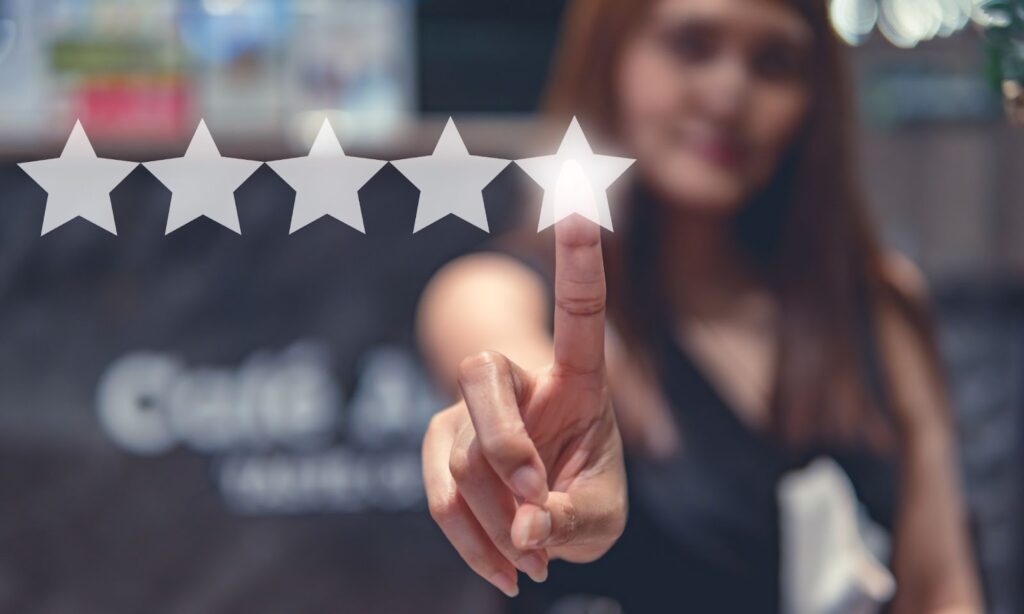 Woman blurred in background has pointer finger in foreground, pointing to image of 5 stars. Topic: testimonials in marketing