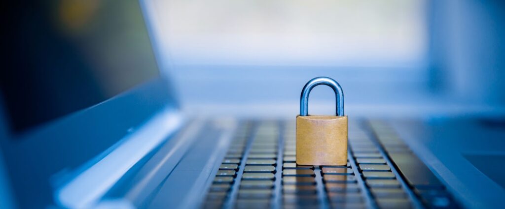 Image of laptop blurred in background. Image of a lock in focused on the foreground. Topic: Data privacy in Online Business