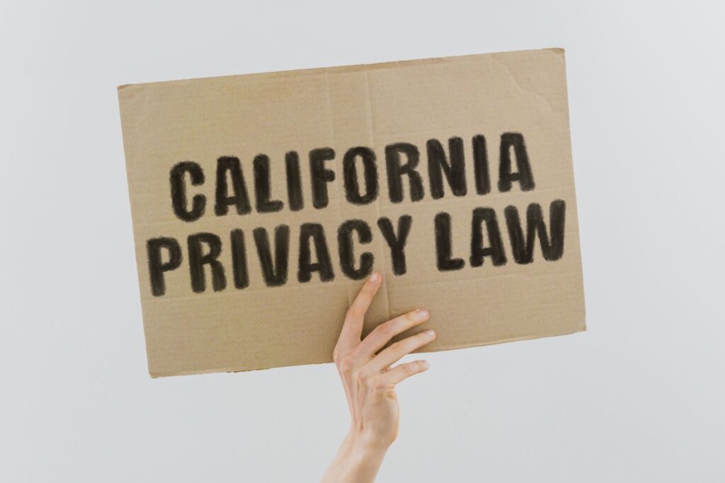 Hand is holding cardboard sign that reads "California Privacy Law".
