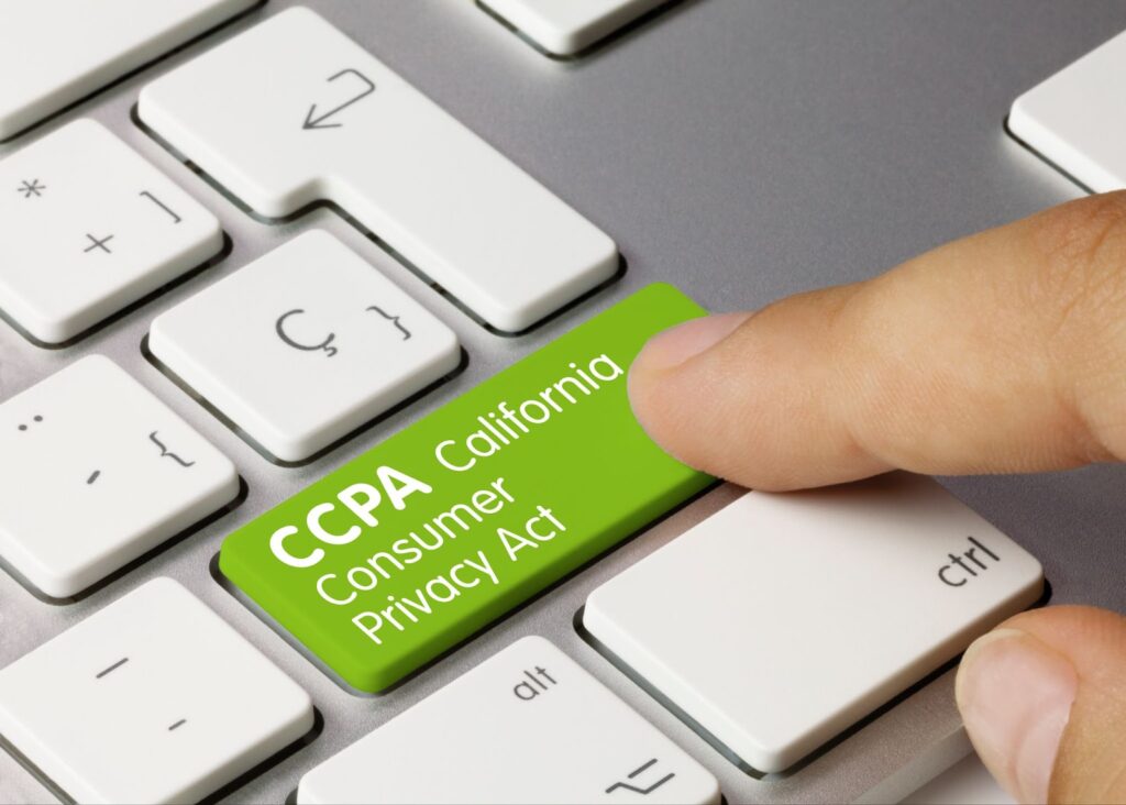 Image of computer keyboard partially visible with green button that reads "CCPA California Consumer Privacy Act" has index finger that is pressing the button. Topic: California Privacy Policy