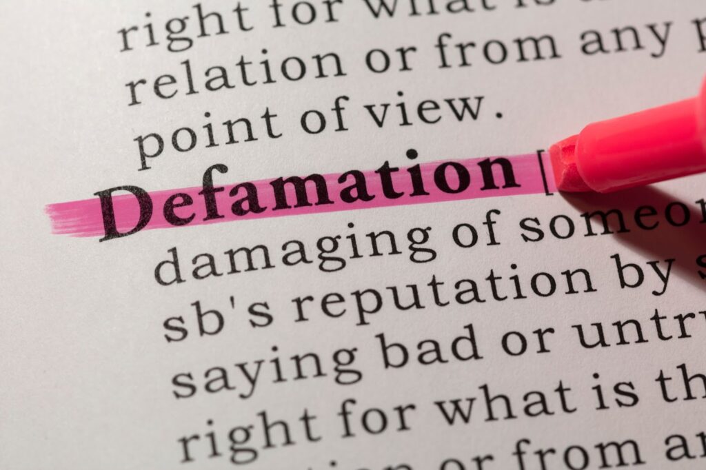 Snippet of the word "defamation" highlighted in pink with the definition written beside the word, only partially visible. Topic:  non-disparagement clause